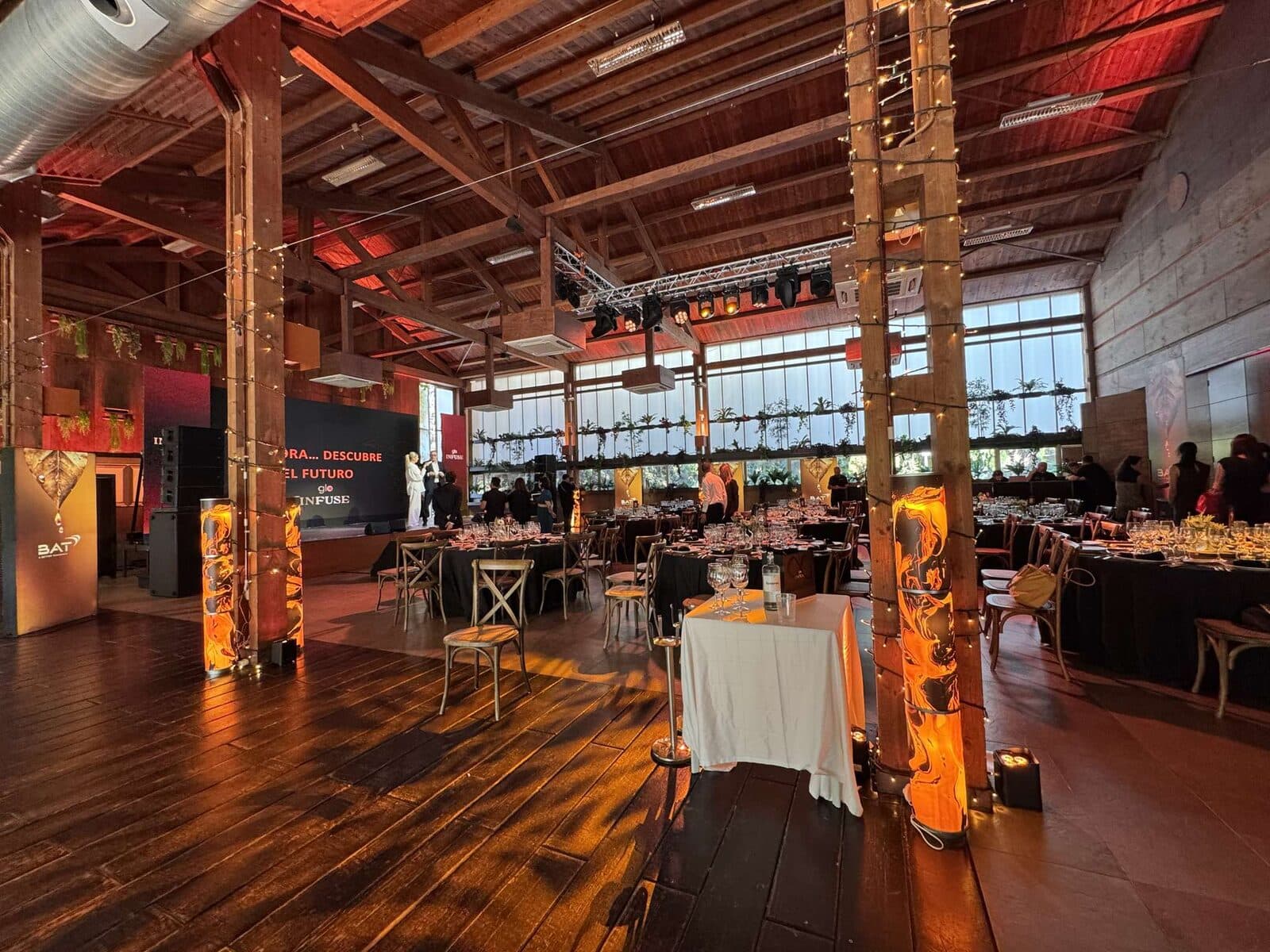 Salón de Finca Sansui montado para una cena de empresa, con escenario y mesas vestidas